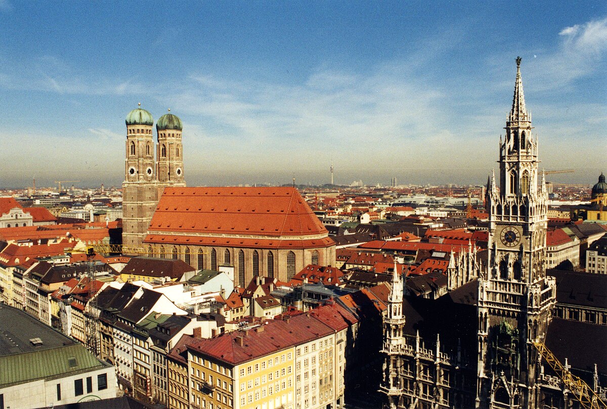 Munich skyline viewed from St. Peter's Church showing the Frauenkirche, New Town Hall, and the Alps in the distance